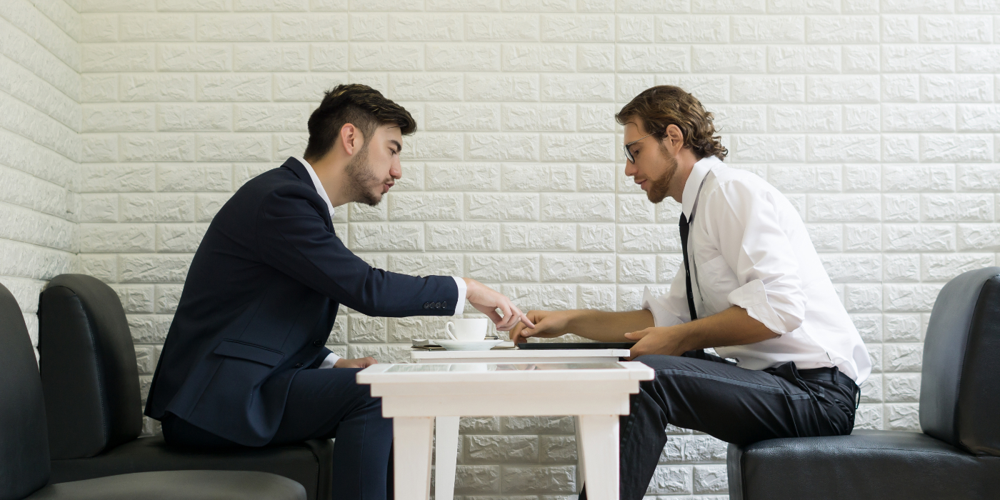 Young businessman talking work with colleague in a modern business lounge. Business working people.