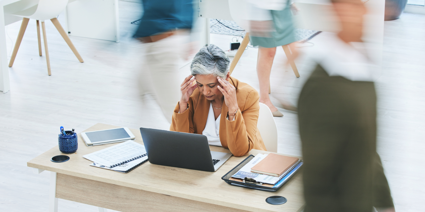 A woman reaching for her temples as a sign of stress